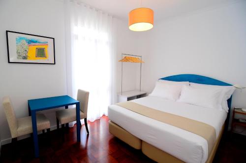 a bedroom with a bed and a table and a chair at VILA ALEGRIA by brugrani in Funchal