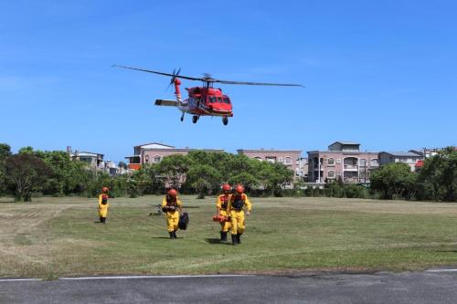 a group of firefighters standing in a field with a helicopter at Oak Garden 有停車位 旅館證號167 民宿證號1359 in Hualien City
