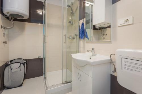 a bathroom with a sink and a shower at Clerisseau Apartments in Pula