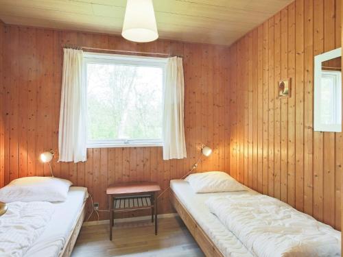 two beds in a room with a window at Holiday home Gedser VIII in Gedser