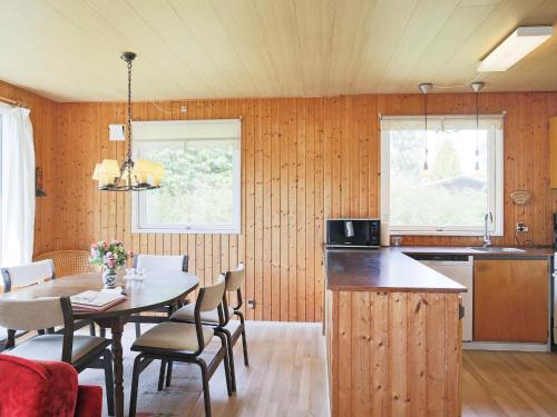 uma cozinha e sala de jantar com mesa e cadeiras em Holiday home Gedser VIII em Gedser