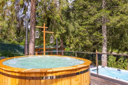 a wooden hot tub in a wooden deck with trees at Garden Wellness Hotel S in Andalo
