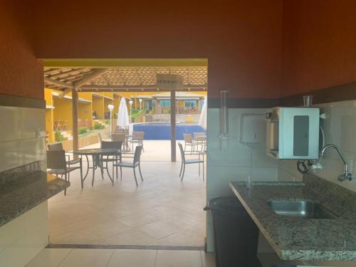 une cuisine et une salle à manger avec une table et des chaises dans l'établissement Condomínio Imbassai Summer Flat, à Imbassaí