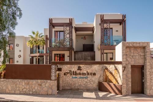 um edifício com uma parede de pedra em frente em Alhambra Boutique Apartments by TAM Resorts em Playa del Inglés