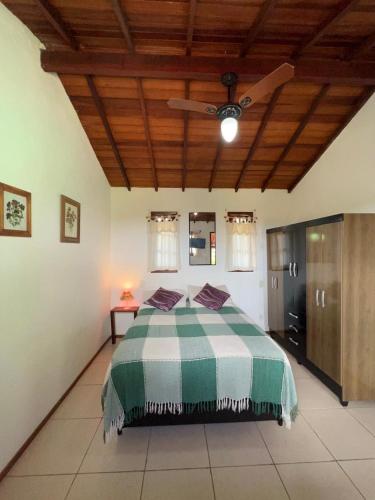 a bedroom with a green and white bed with a ceiling at Buzios Casa n# 2 in Búzios