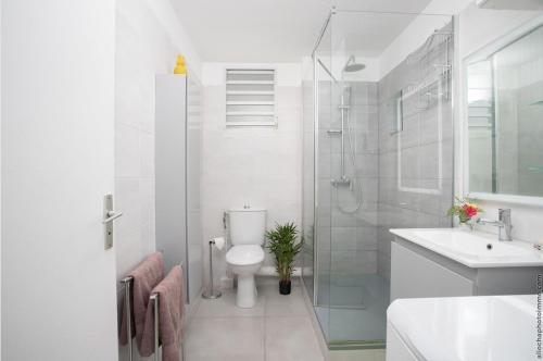 ein Bad mit einem WC, einer Dusche und einem Waschbecken in der Unterkunft Navira Appartement Bleu Nuit in Quartier Châteauboeuf