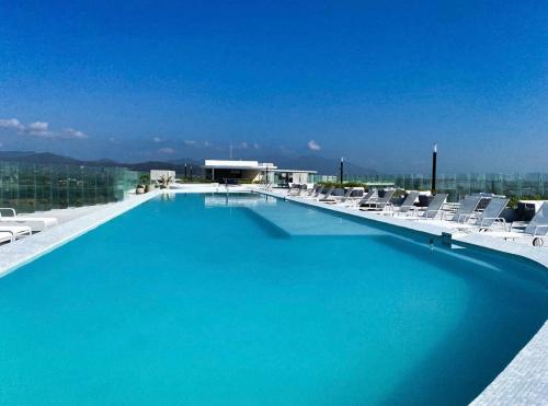 a large swimming pool with lounge chairs on a building at Maritima in Nuevo Vallarta