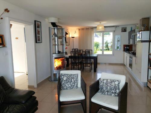 un salon avec deux chaises et une cheminée dans l'établissement Beachfront Apartment in Plouguerneau, à Plouguerneau