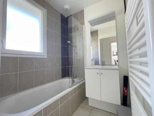 ein Badezimmer mit Badewanne, Waschbecken und Spiegel in der Unterkunft Maisonnette 4 pers avec terrasse privée et accès piscine, proche océan - Saint-Brevin-les-Pins - FR-1-364-102 in Saint-Brevin-les-Pins