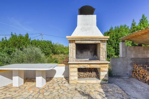 a stone barbecue with a table and a fireplace at Apartment S and E in Kali