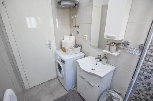W łazience znajduje się pralka i umywalka. w obiekcie Apartment S and E w mieście Kali