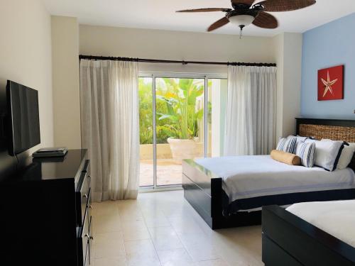 a bedroom with two beds and a sliding glass door at Luxury Marina Front Condo Cap Cana, Punta Cana in Punta Cana