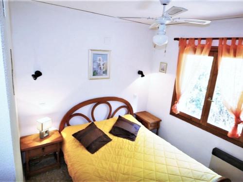 a bedroom with a yellow bed and a window at Coastal Comfort with Pool in Denia