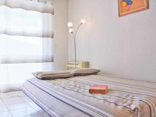 Ce lit se trouve dans un dortoir doté d'une lampe. dans l'établissement Appartement T2 climatisé avec piscine, terrasse et parking à 600m de la plage - Le Lavandou - FR-1-251-399, au Lavandou