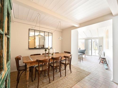 une salle à manger avec une table et des chaises en bois dans l'établissement Maison Rénovée avec Jacuzzi et Cuisine d'Été au Centre du Village - FR-1-434-97, à La Couarde-sur-Mer