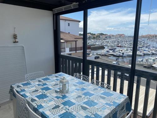 une table sur un balcon avec vue sur un port dans l'établissement Studio 4 pers avec terrasse et parking à Capbreton - FR-1-413-199, à Capbreton