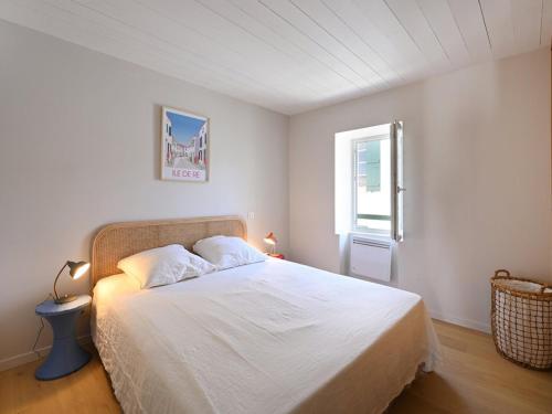 a bedroom with a white bed with a window at Maison Rénovée avec Jacuzzi et Cuisine d'Été au Centre du Village - FR-1-434-97 in La Couarde-sur-Mer