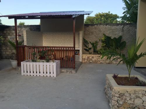 une terrasse couverte d'une maison avec une clôture et des plantes dans l'établissement LOPE HOMESTAY, à Ndangu