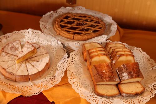 three different types of bread and pies on white plates at Hotel Serena srl in Rome