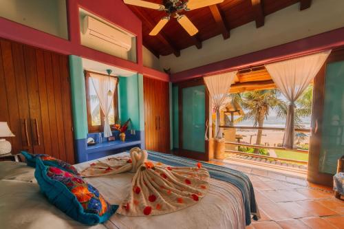 a bedroom with a large bed and a large window at Tres Mujeres Hotel in Troncones