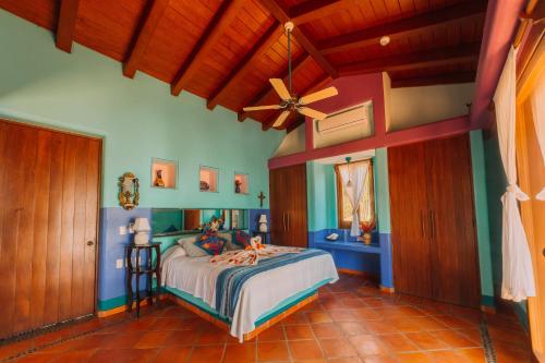 a bedroom with a bed and a ceiling fan at Tres Mujeres Hotel in Troncones