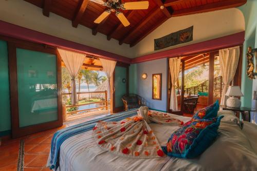 a bedroom with a large bed in a room with windows at Tres Mujeres Hotel in Troncones