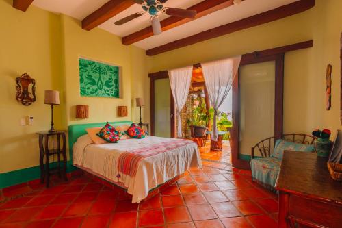 a bedroom with a bed and a couch in a room at Tres Mujeres Hotel in Troncones