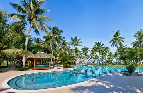 a swimming pool with palm trees and a gazebo at Lomani Island Resort &ndash; Adults Only in Malolo Lailai