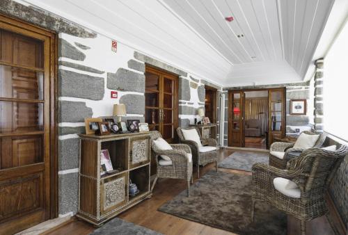 a living room with chairs and a stone wall at Quinta da Vargem in Unhais da Serra