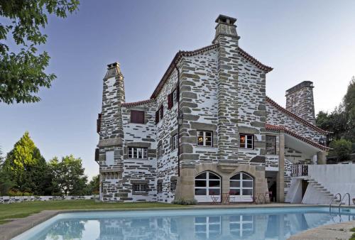 a stone house with a pool in front of it at Quinta da Vargem in Unhais da Serra