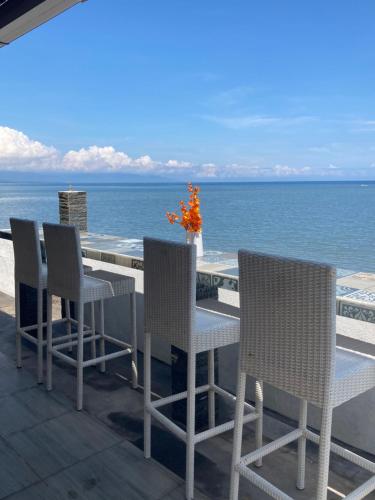 a table and chairs on a patio overlooking the ocean at Villa Agung Beach Inn in Lovina