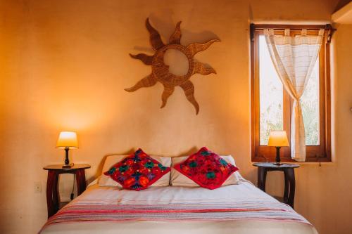 a bedroom with a bed with two pillows on it at Tres Mujeres Hotel in Troncones