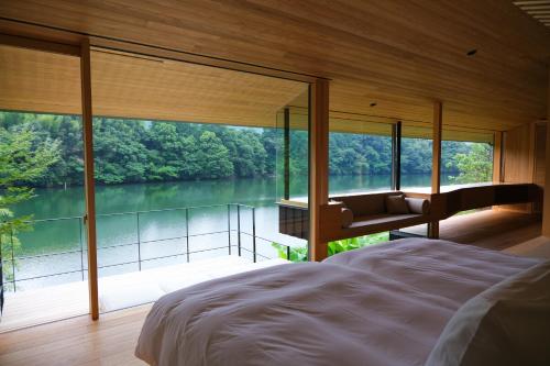 a bedroom with a large window with a view of a lake at Kohanyu in Kami