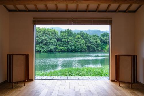 a room with a view of a lake through a window at Kohanyu in Kami