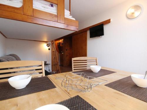 - une salle à manger avec une table en bois et des bols blancs dans l'établissement Studio lumineux au pied des pistes, balcon Sud-Ouest, Wi-Fi gratuit, 4 pers, Arc 1800 - FR-1-346-391, à Arc 1800