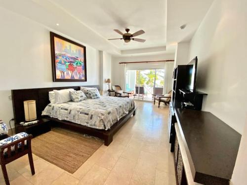 een slaapkamer met een bed en een flatscreen-tv bij Perfect Beach Condo Cap Cana Marina, Punta Cana in Punta Cana