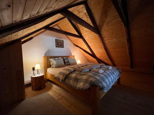 a bedroom with a bed in an attic at Naša mala koliba in Vojnić