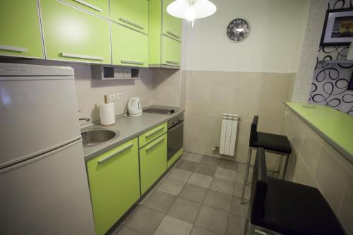 a small kitchen with green cabinets and a sink at Vip apartment Beograd in Belgrade