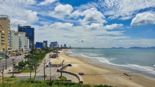een uitzicht op een strand met gebouwen en de oceaan bij One Room in Vung Tau