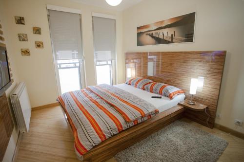 a bedroom with a large bed with a wooden headboard at Vip apartment Beograd in Belgrade