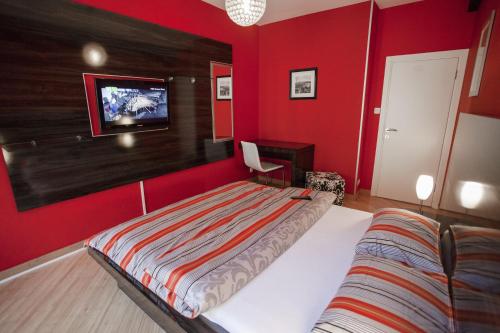 a red bedroom with a bed and a tv on the wall at Vip apartment Beograd in Belgrade
