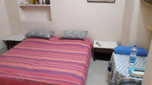 a small bedroom with a bed and a bottle of water at Judges Court in Puri