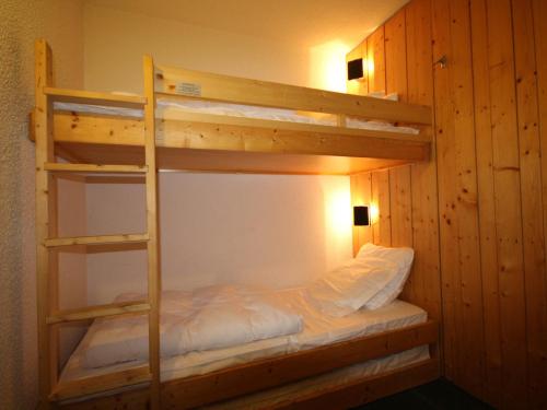 Ce lit superposé se trouve dans un dortoir avec une échelle. dans l'établissement Studio agréable au centre station avec balcon et Wifi gratuit - FR-1-346-489, à Arc 1800