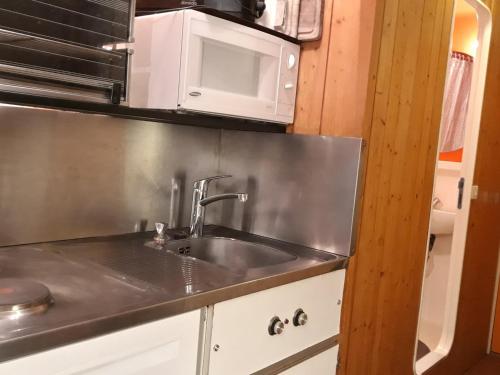 une cuisine avec un évier et un micro-ondes dans l'établissement Studio au pied des pistes avec balcon et wifi - FR-1-346-503, à Arc 1800