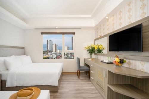 a hotel room with a bed and a flat screen tv at Royal Beach Hotel by THG in Da Nang