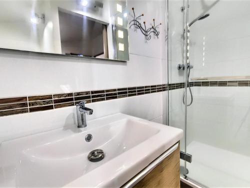une salle de bain avec un lavabo et une douche dans l'établissement Duplex rénové, 8/10 pers, skis aux pieds, balcon sud, calme, piscine chauffée - FR-1-267-180, au Corbier