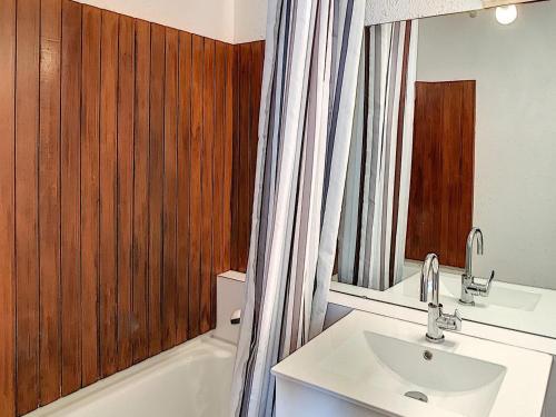 une salle de bain avec un lavabo, des toilettes et une baignoire dans l'établissement Appartement lumineux en centre station avec balcon et accès piscine - FR-1-267-200, au Corbier