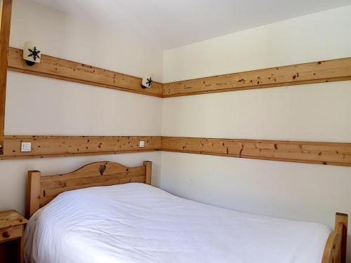 Schlafzimmer mit einem weißen Bett und Holzwänden in der Unterkunft Appartement Les Menuires, 3 pièces, 6 personnes - FR-1-344-758 in Levassaix