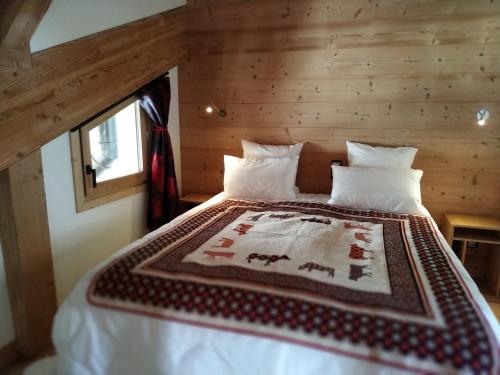 une chambre avec un lit avec une couverture dessus dans l'établissement Chalet Serendipity · Accès pistes · Grand confort · Parking couvert · Wifi · Sauna - FR-1-344-731, à Saint-Martin-de-Belleville