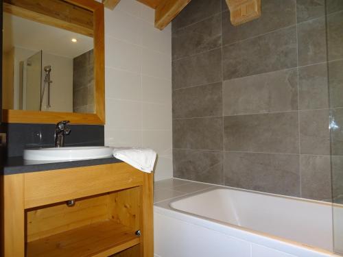 une salle de bain avec une baignoire et un lavabo et une baignoire tubermottermott dans l'établissement Chalet Pomme de Pin · Direct sur la piste · Wifi gratuit · Sauna · Parking couvert · Proche télécabine - FR-1-344-759, à Saint-Martin-de-Belleville